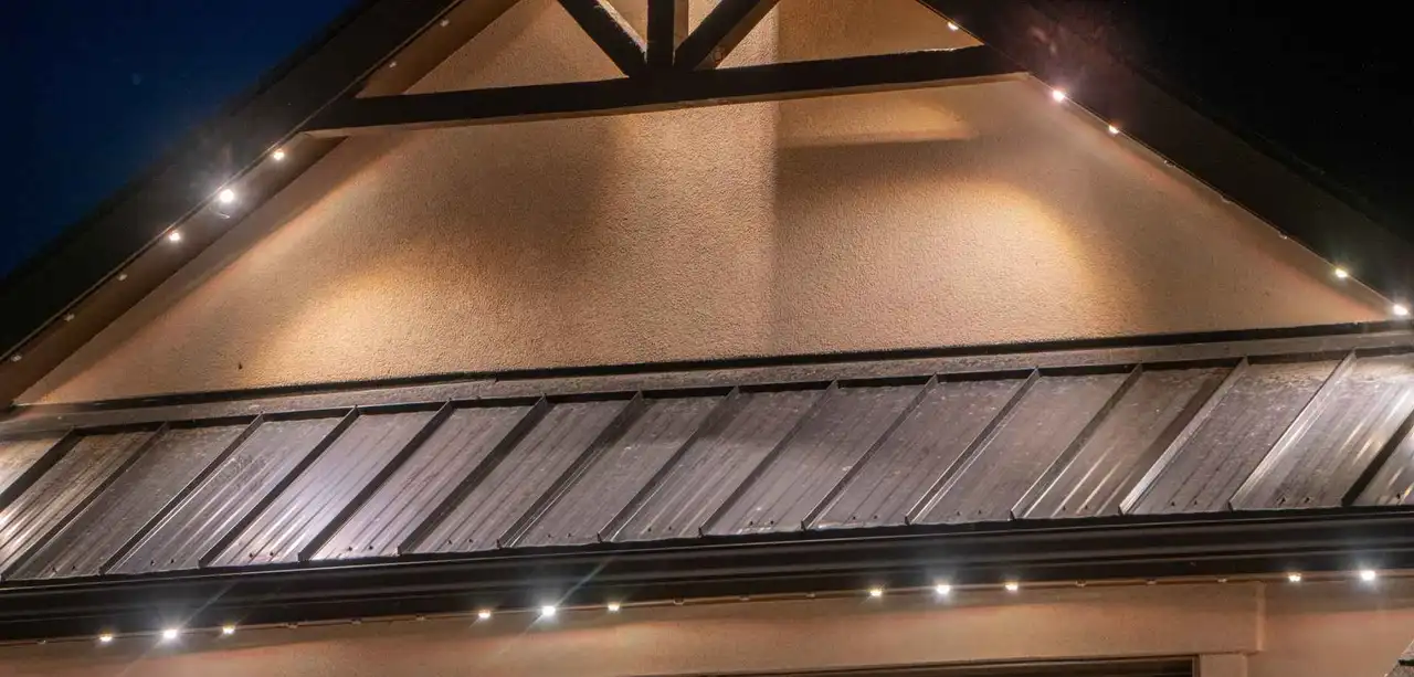 Close-up of the Bosso lighting track fitted under a gable eave, showing the individual fixtures